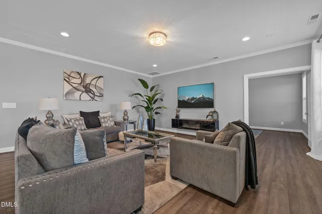 a dining room with furniture a potted plant and wooden floor