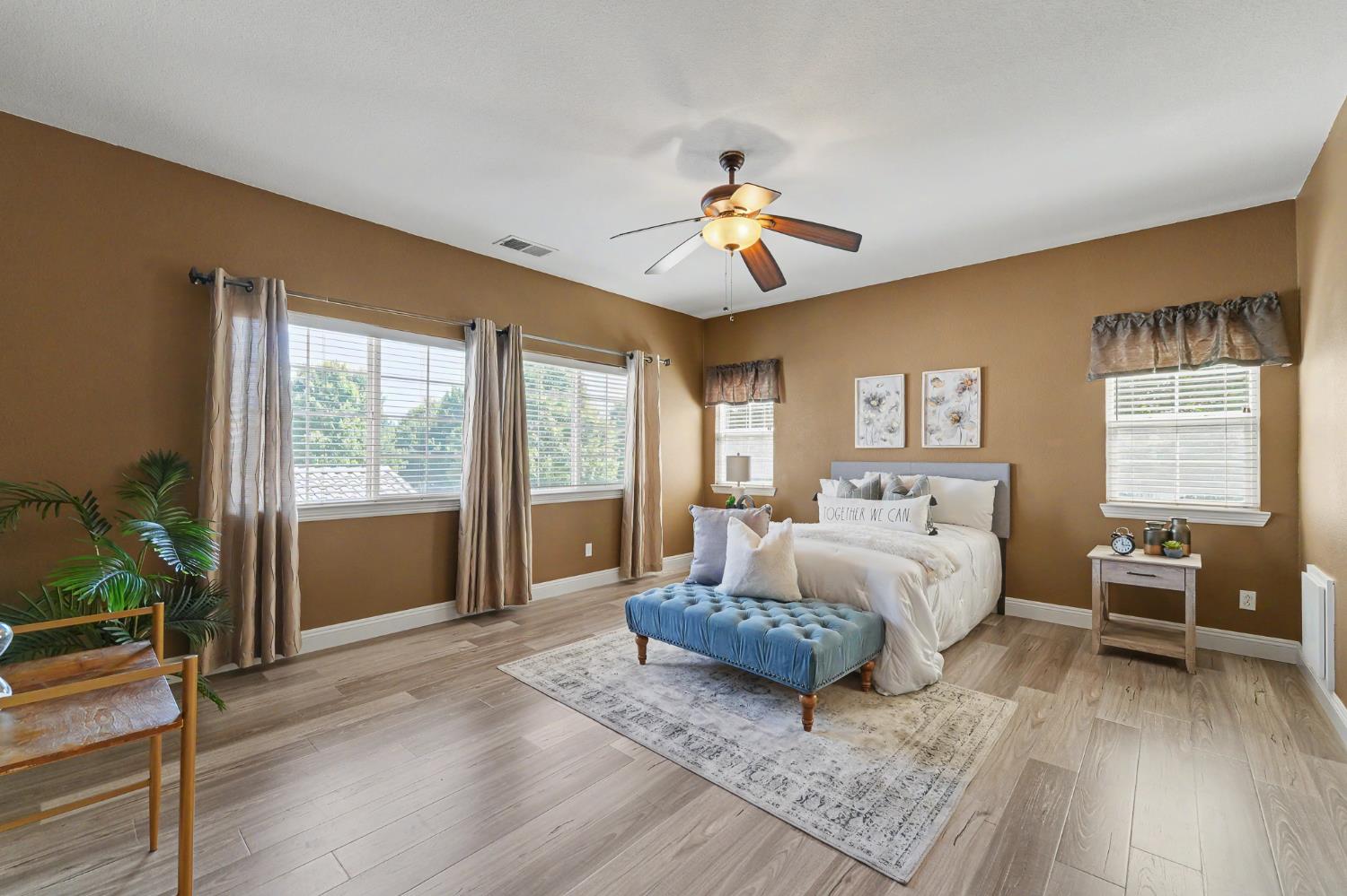 1223 East Springer Drive Turlock, CA 95382 - Photo 25 of 48 a spacious bedroom with a large bed and a chandelier