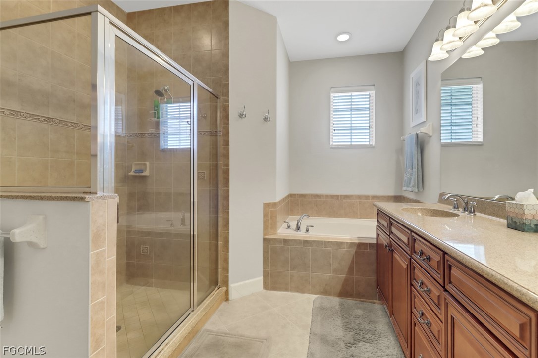 13020 Pebblebrook Point Circle, Unit 202 Fort Myers, FL 33905 - Photo 18 of 40 a bathroom with a tub sink and mirror