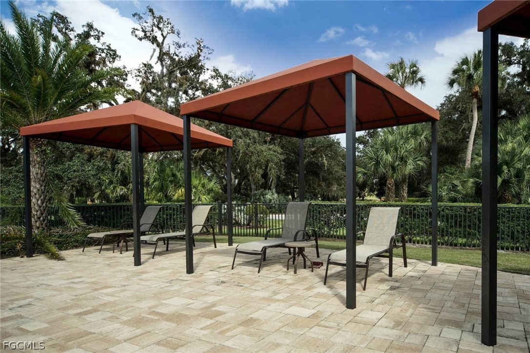 13020 Pebblebrook Point Circle, Unit 202 Fort Myers, FL 33905 - Photo 25 of 40 a view of chair and tables with umbrella in the patio