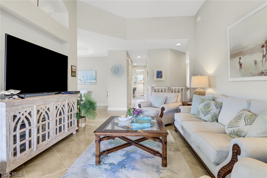 13020 Pebblebrook Point Circle, Unit 202 Fort Myers, FL 33905 - Photo 6 of 40 a living room with furniture and a flat screen tv