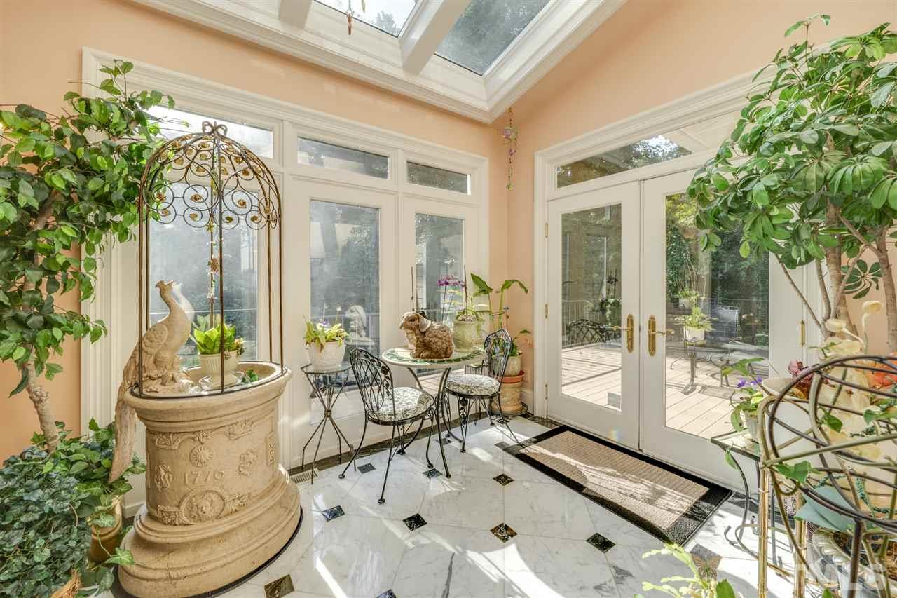 1112 Hymettus Court Raleigh, NC 27607 - Photo 9 of 29 a view of a patio with table and chairs potted plants and floor to ceiling window