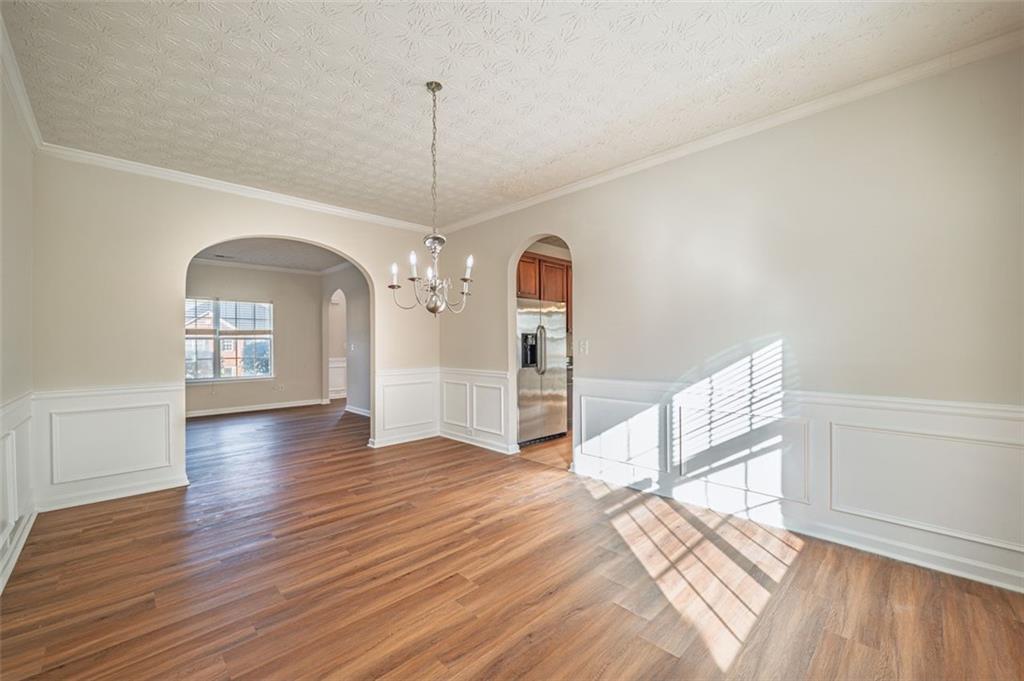 3017 Bellingham Way Lithia Springs, GA 30122 - Photo 17 of 44 a view of a room with wooden floor staircase and a kitchen