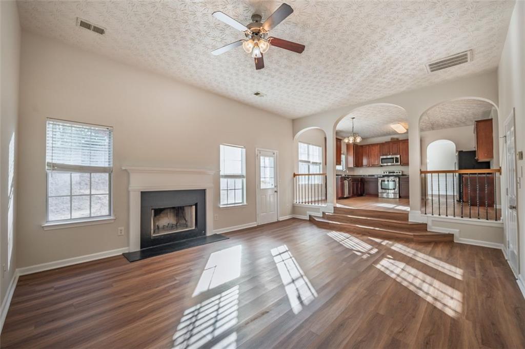 3017 Bellingham Way Lithia Springs, GA 30122 - Photo 18 of 44 a view of a livingroom with wooden floor a fireplace and windows