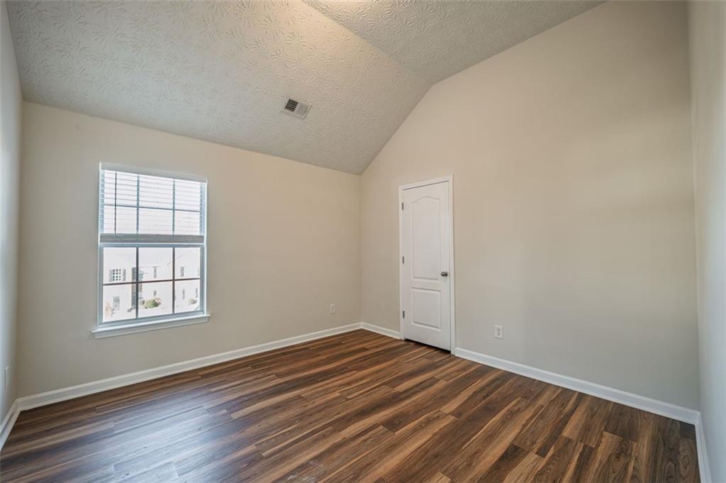 3017 Bellingham Way Lithia Springs, GA 30122 - Photo 32 of 44 an empty room with wooden floor and windows
