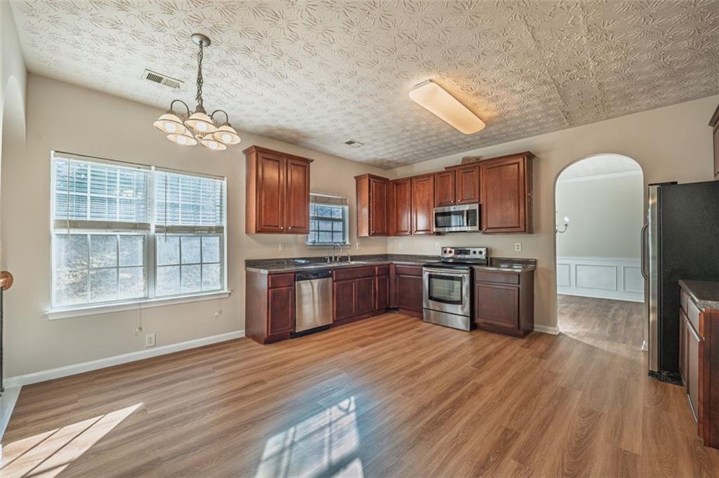 3017 Bellingham Way Lithia Springs, GA 30122 - Photo 7 of 44 a kitchen with stainless steel appliances granite countertop a stove sink and refrigerator