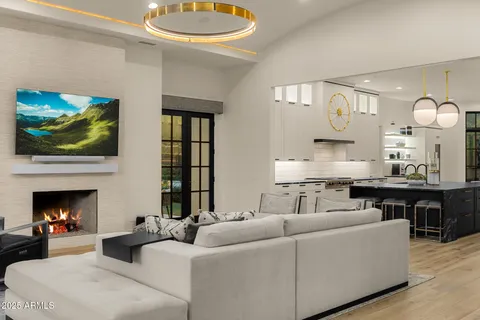 a kitchen with stainless steel appliances granite countertop a stove a refrigerator a sink a dining table and chairs with wooden floor