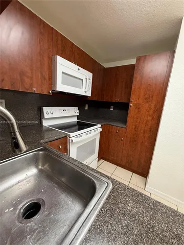 a kitchen with a sink and a stove top oven