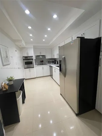 a kitchen with stainless steel appliances a refrigerator and a stove top oven
