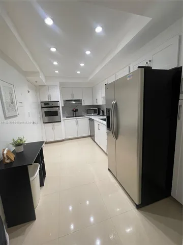 a kitchen with stainless steel appliances a refrigerator and a stove top oven