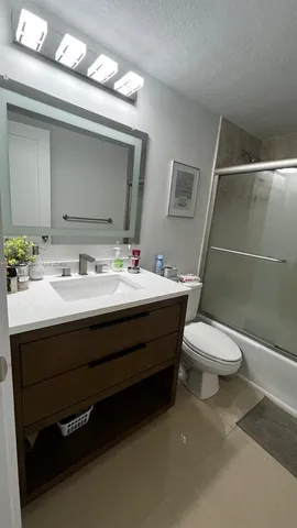 a bathroom with a sink mirror and toilet