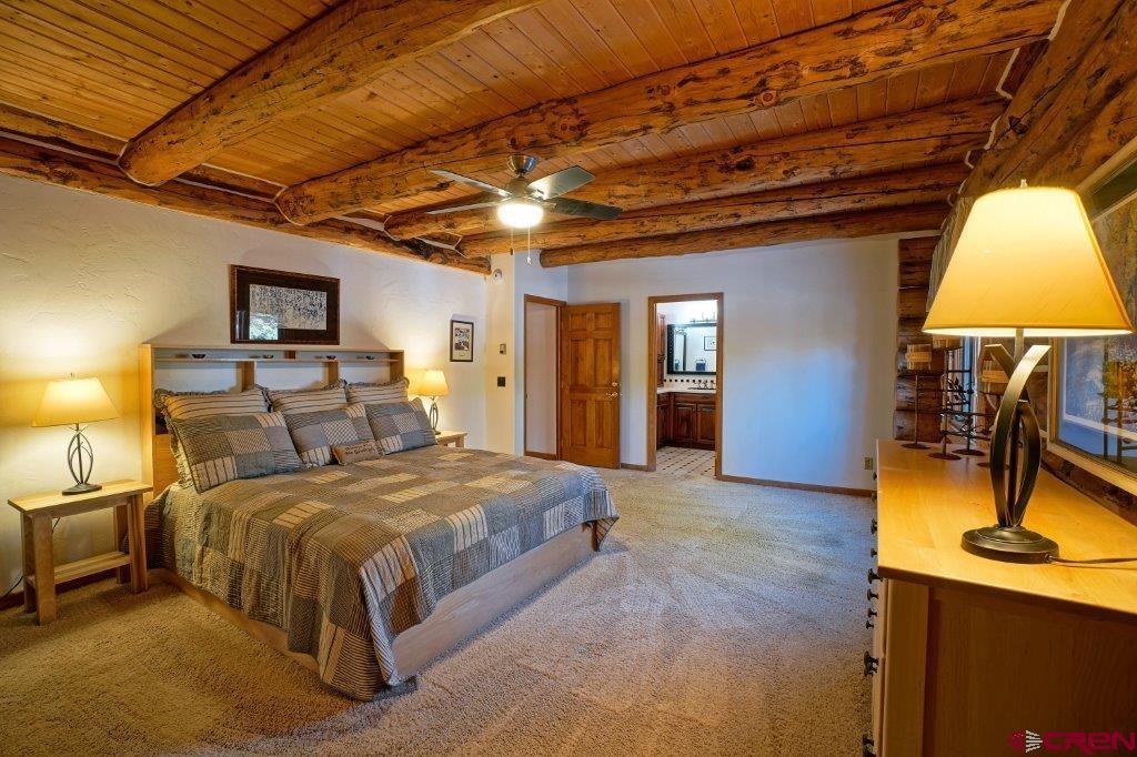 653 Marmot Drive Ridgway, CO 81432 - Photo 26 of 44 a bedroom with a bed and a chandelier