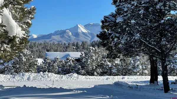 a view of a dining room with furniture water view and a floor to ceiling window