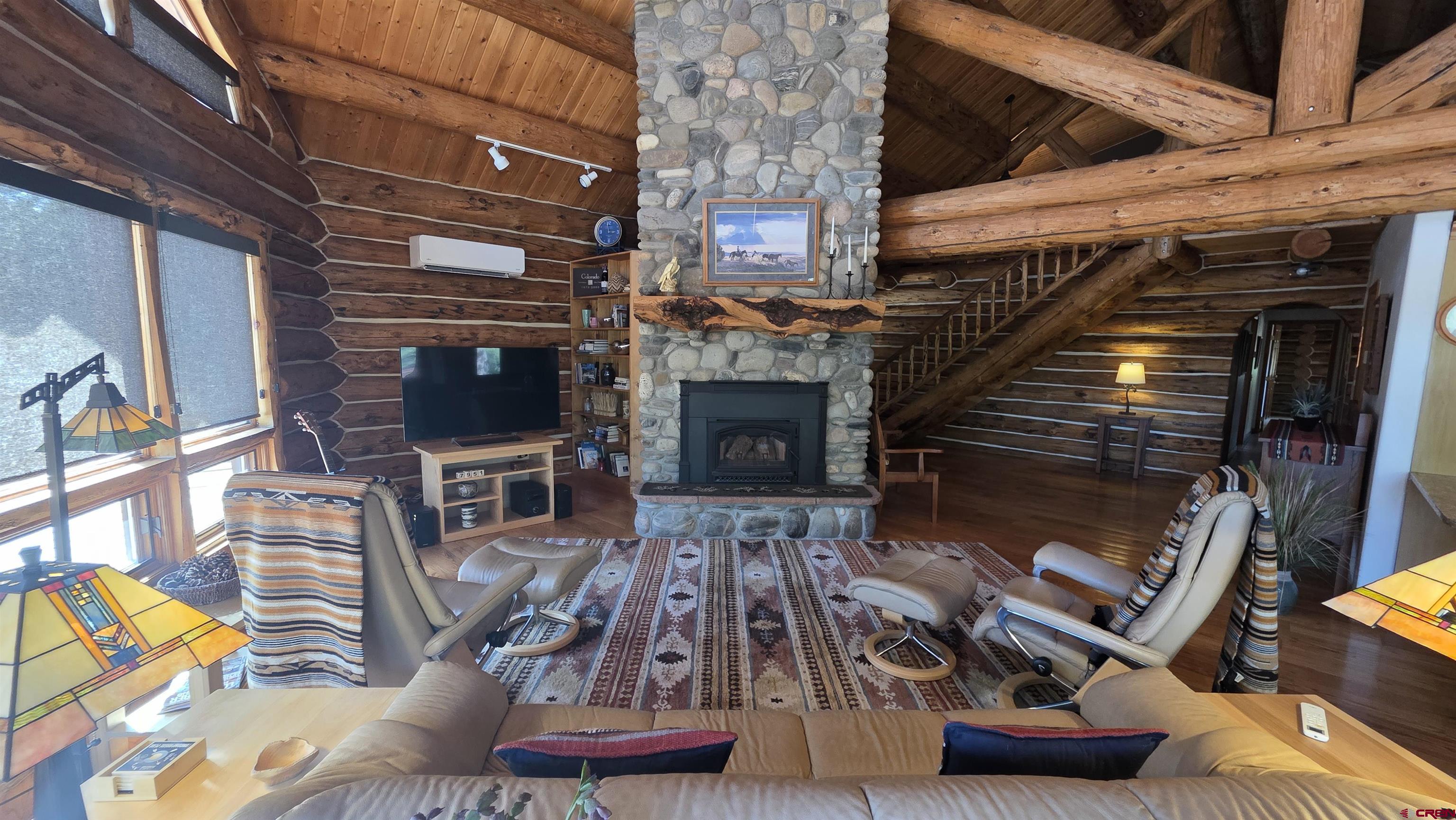 653 Marmot Drive Ridgway, CO 81432 - Photo 10 of 44 a living room with furniture a flat screen tv and a fireplace