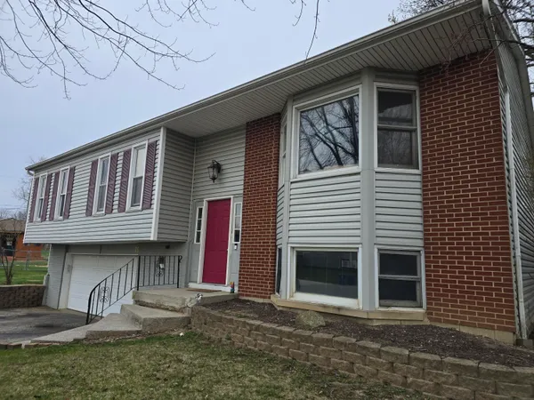 a view of a house with a yard and large tree