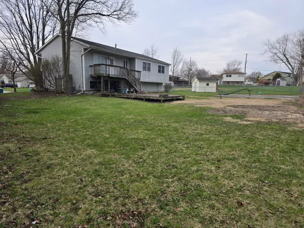 a view of a yard in front of a house with large tree