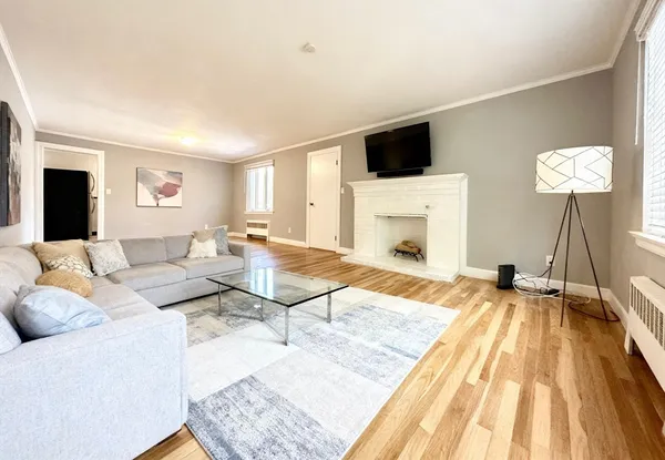 a living room with furniture fireplace and a window