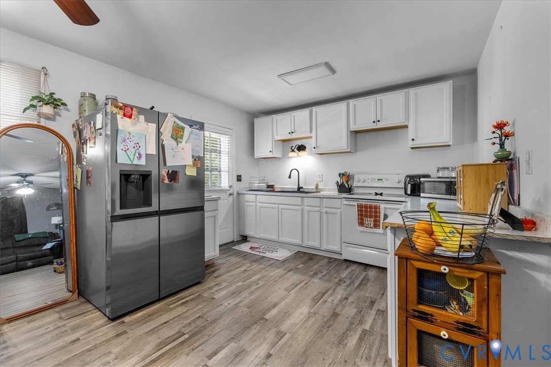 2224 Butler Branch Road Petersburg, VA 23805 - Photo 19 of 24 a kitchen with stainless steel appliances a refrigerator sink and wooden floor