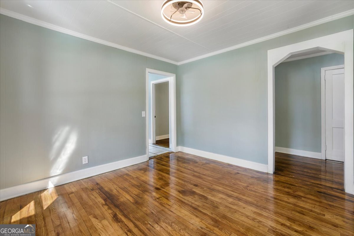 360 North Lewis Street Metter, GA 30439 - Photo 15 of 39 an empty room with wooden floor and windows