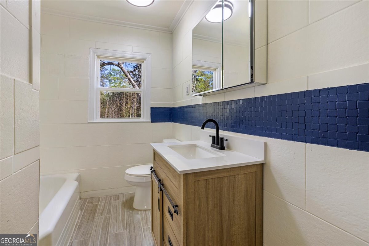 360 North Lewis Street Metter, GA 30439 - Photo 27 of 39 a bathroom with a sink a toilet and mirror