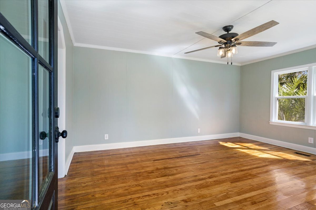 360 North Lewis Street Metter, GA 30439 - Photo 8 of 39 an empty room with wooden floor fan and windows