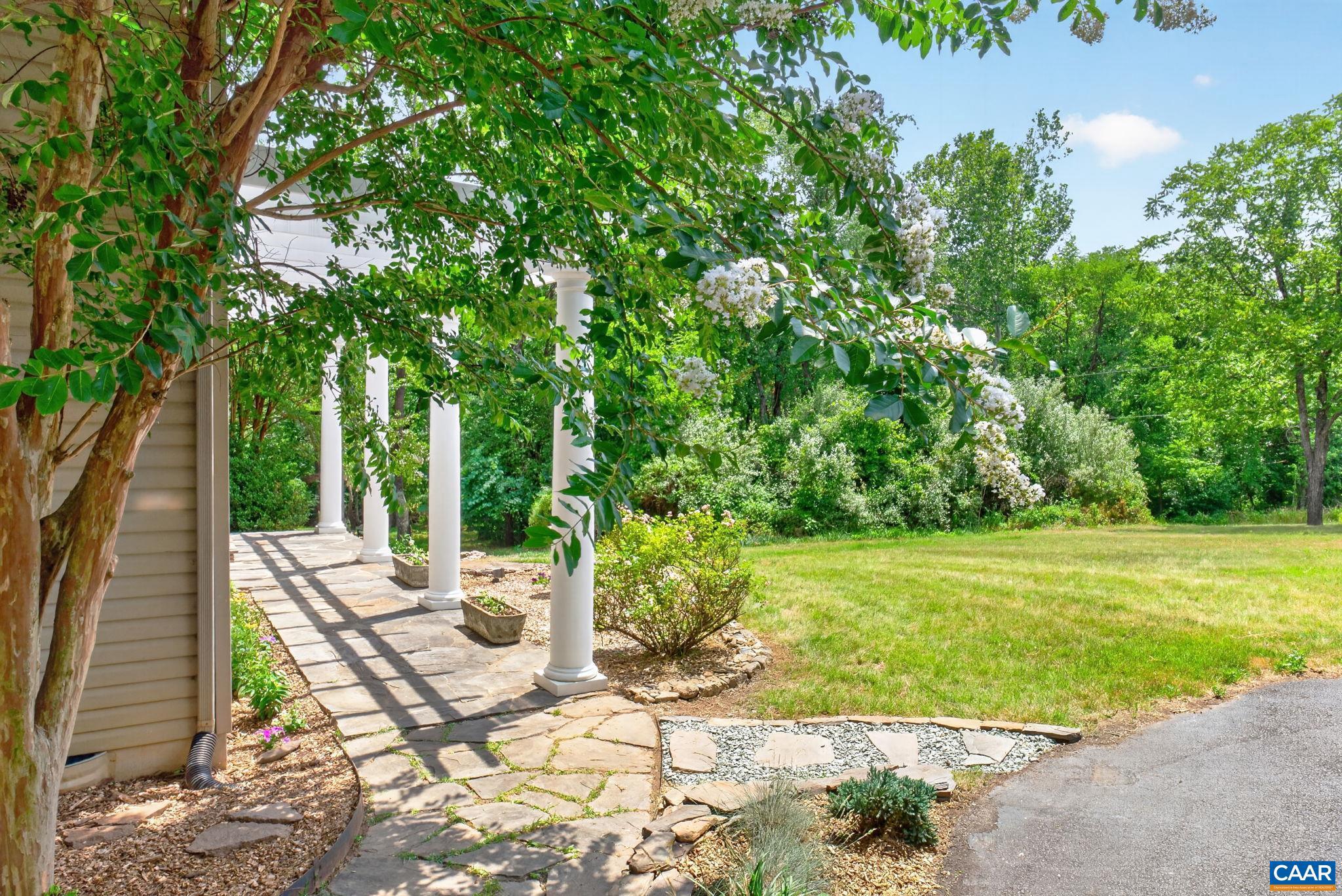 6285 Jarmans Gap Road Crozet, VA 22932 - Photo 54 of 65 a view of a patio with table and chairs potted plants and large tree