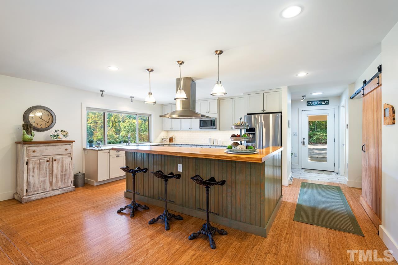 2639 Umstead Road Durham, NC 27712 - Photo 14 of 42 a kitchen with stainless steel appliances granite countertop a refrigerator a sink dishwasher a stove and white countertops with wooden floor