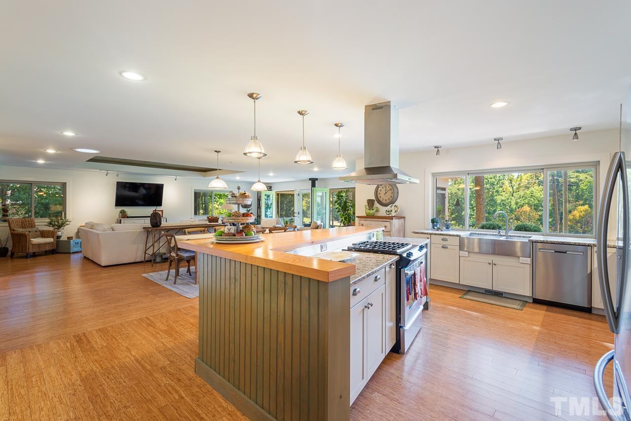 2639 Umstead Road Durham, NC 27712 - Photo 15 of 42 a kitchen with kitchen island granite countertop a stove and a sink