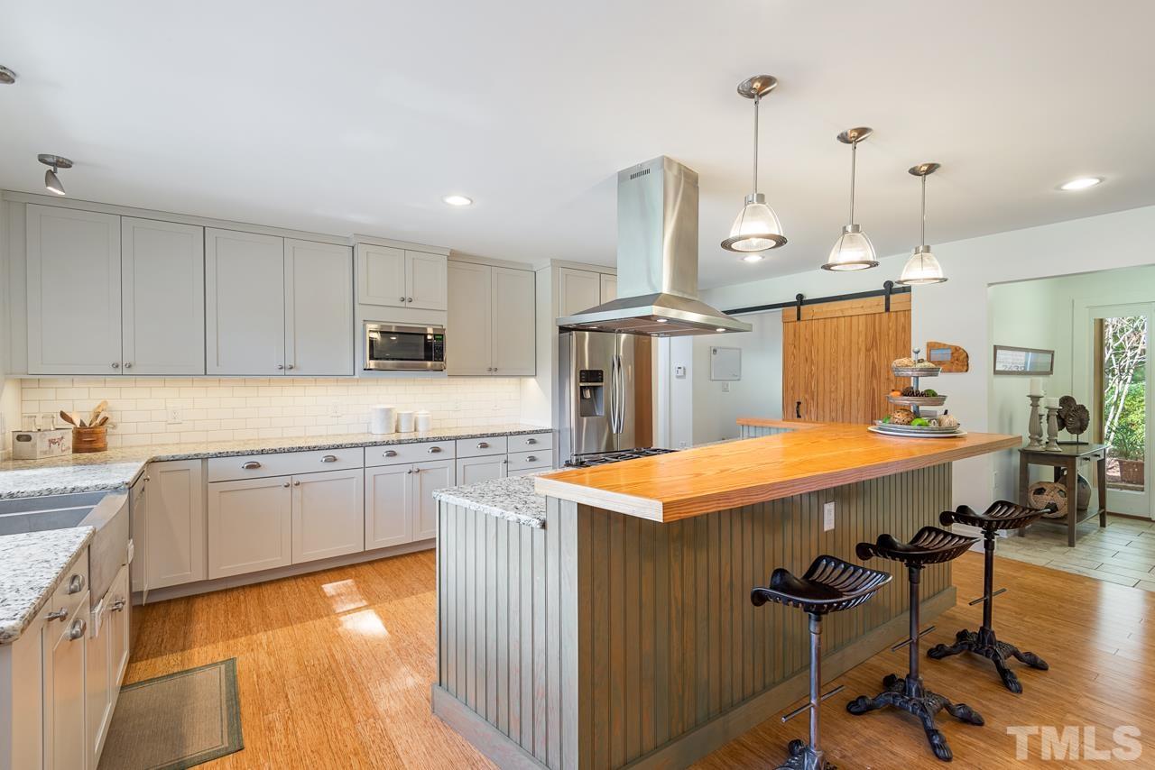 2639 Umstead Road Durham, NC 27712 - Photo 17 of 42 a kitchen with stainless steel appliances granite countertop a sink a stove and a wooden floors