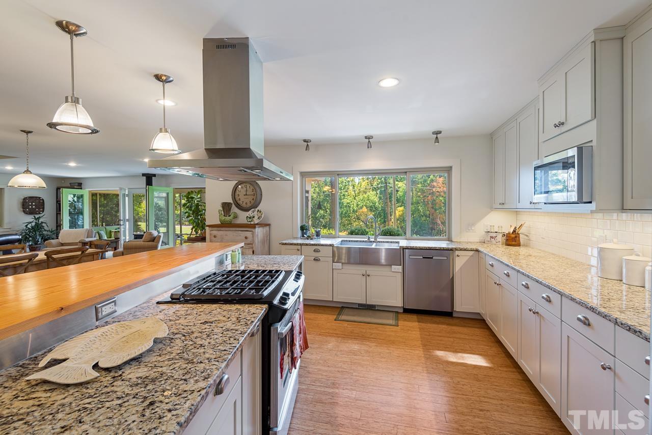 2639 Umstead Road Durham, NC 27712 - Photo 20 of 42 a kitchen with stainless steel appliances granite countertop a stove a sink and a wooden floors