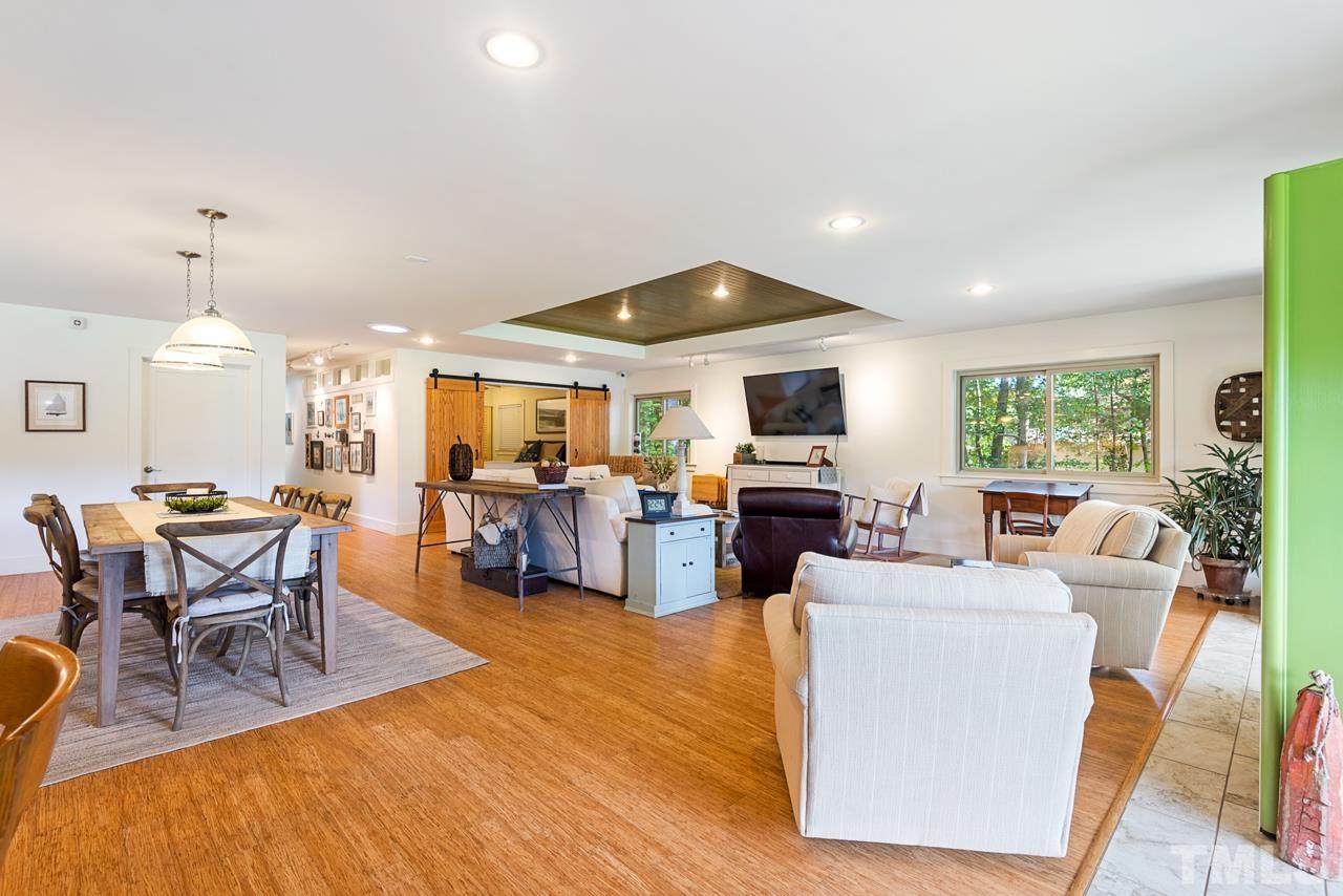 2639 Umstead Road Durham, NC 27712 - Photo 9 of 42 a living room with furniture a fireplace and a dining table with wooden floor