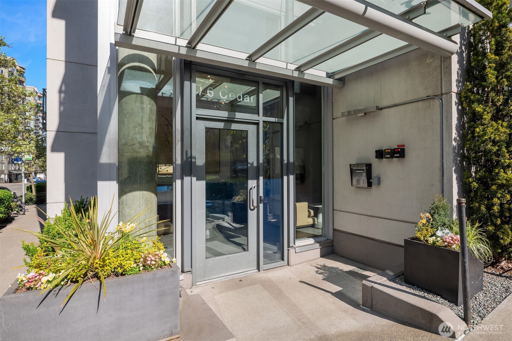 76 Cedar Street, Unit 609 Seattle, WA 98121 - Photo 3 of 31 a glass door with a potted plant on the side of a building