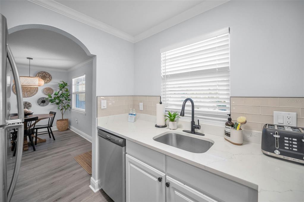 19417 Gulf Boulevard, Unit F207 Indian Rocks Beach, FL 33785 - Photo 14 of 56 a kitchen with sink a window and wooden floor