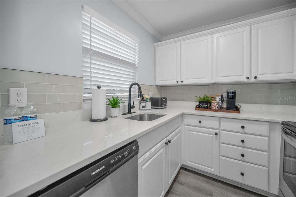 19417 Gulf Boulevard, Unit F207 Indian Rocks Beach, FL 33785 - Photo 10 of 56 a kitchen with a sink and cabinets