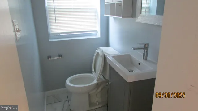 a bathroom with a sink a toilet and a window