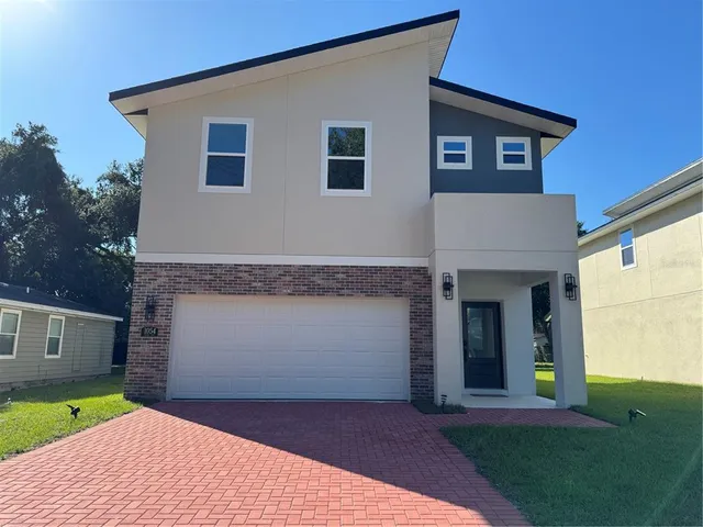 a front view of a house with a yard and trees
