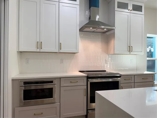 a kitchen with granite countertop white cabinets and white appliances