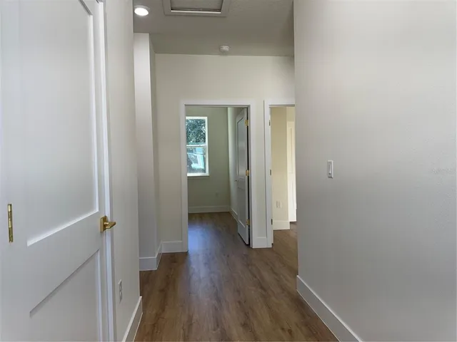 a view of a hallway with wooden floor