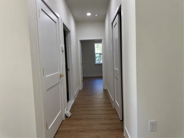 a view of a hallway with wooden floor