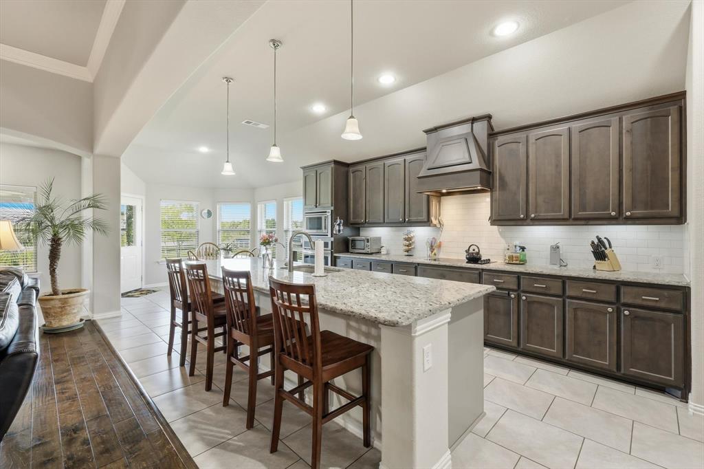113 Heather Lane Decatur, TX 76234 - Photo 11 of 32 a kitchen with kitchen island granite countertop wooden cabinets a center island and appliances