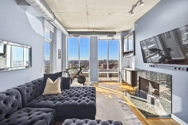 a living room with furniture large window and a fireplace