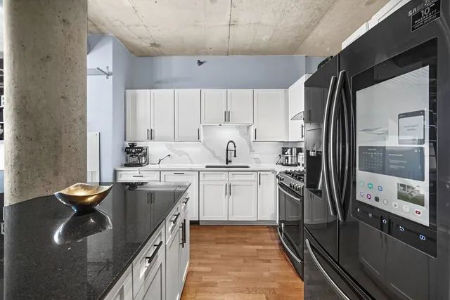 a kitchen with white cabinets and stainless steel appliances