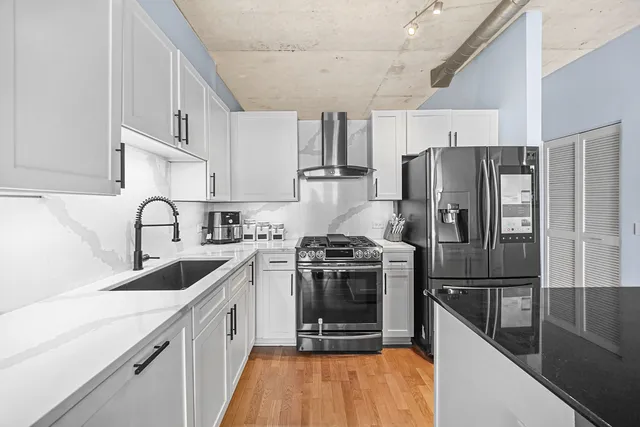 a kitchen with stainless steel appliances granite countertop a sink stove and refrigerator