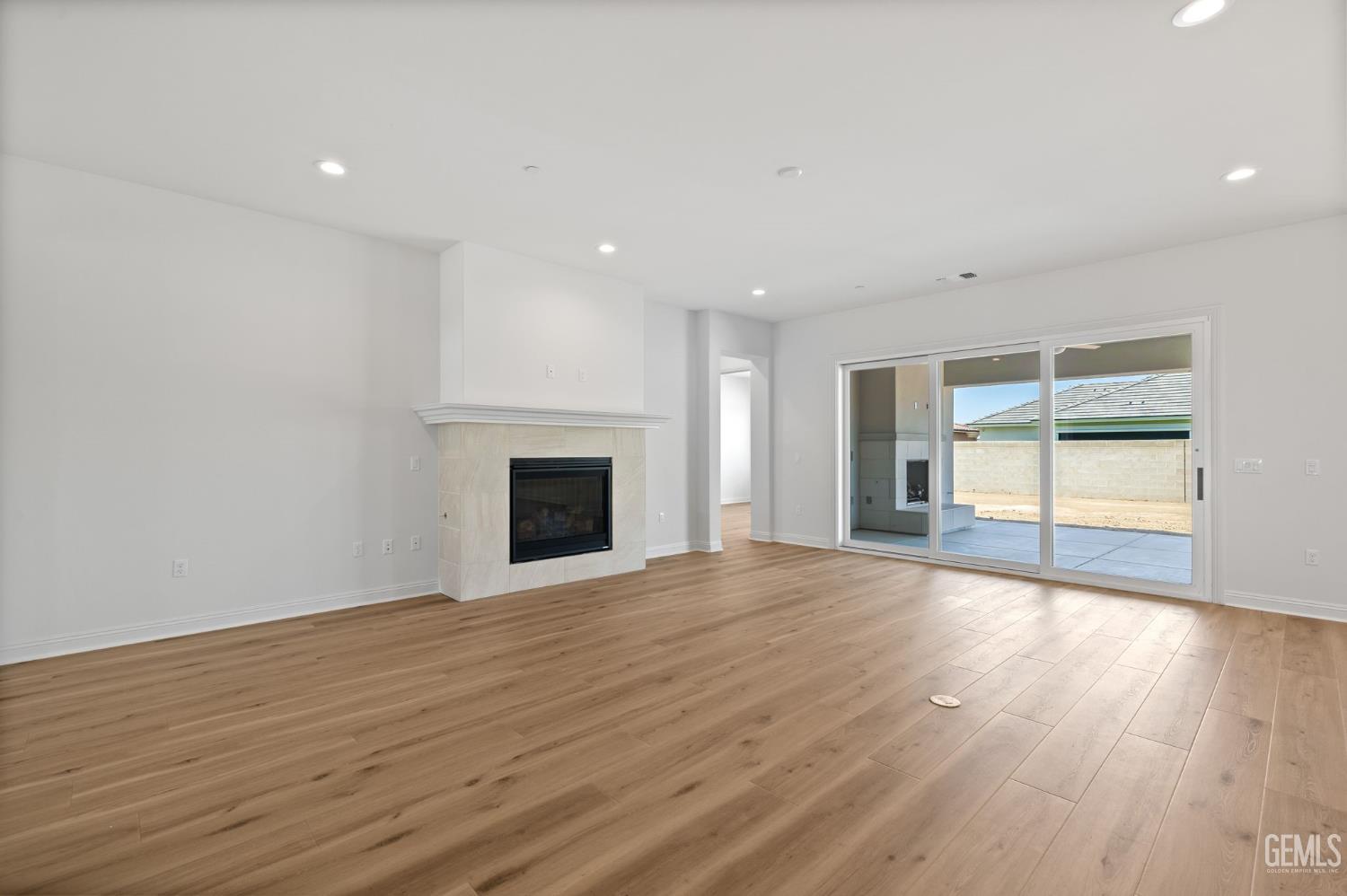 Undisclosed Address Bakersfield, CA 93311 - Photo 14 of 71 an empty room with wooden floor fireplace and windows