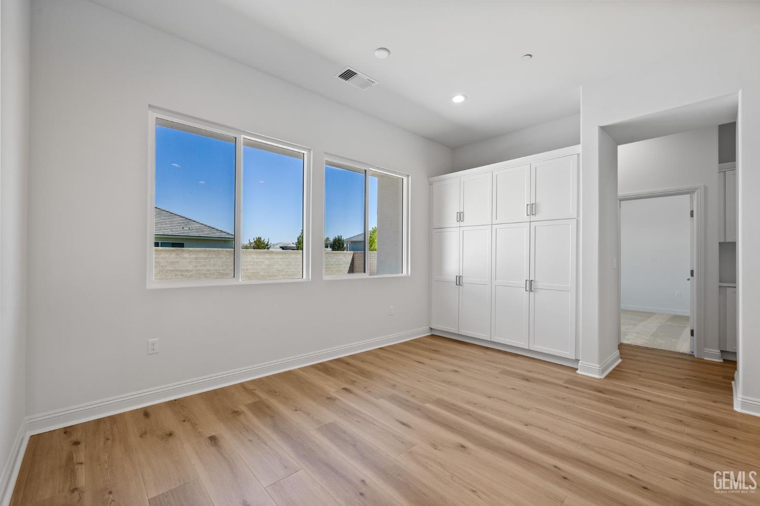 Undisclosed Address Bakersfield, CA 93311 - Photo 21 of 71 a view of an empty room with wooden floor and a window