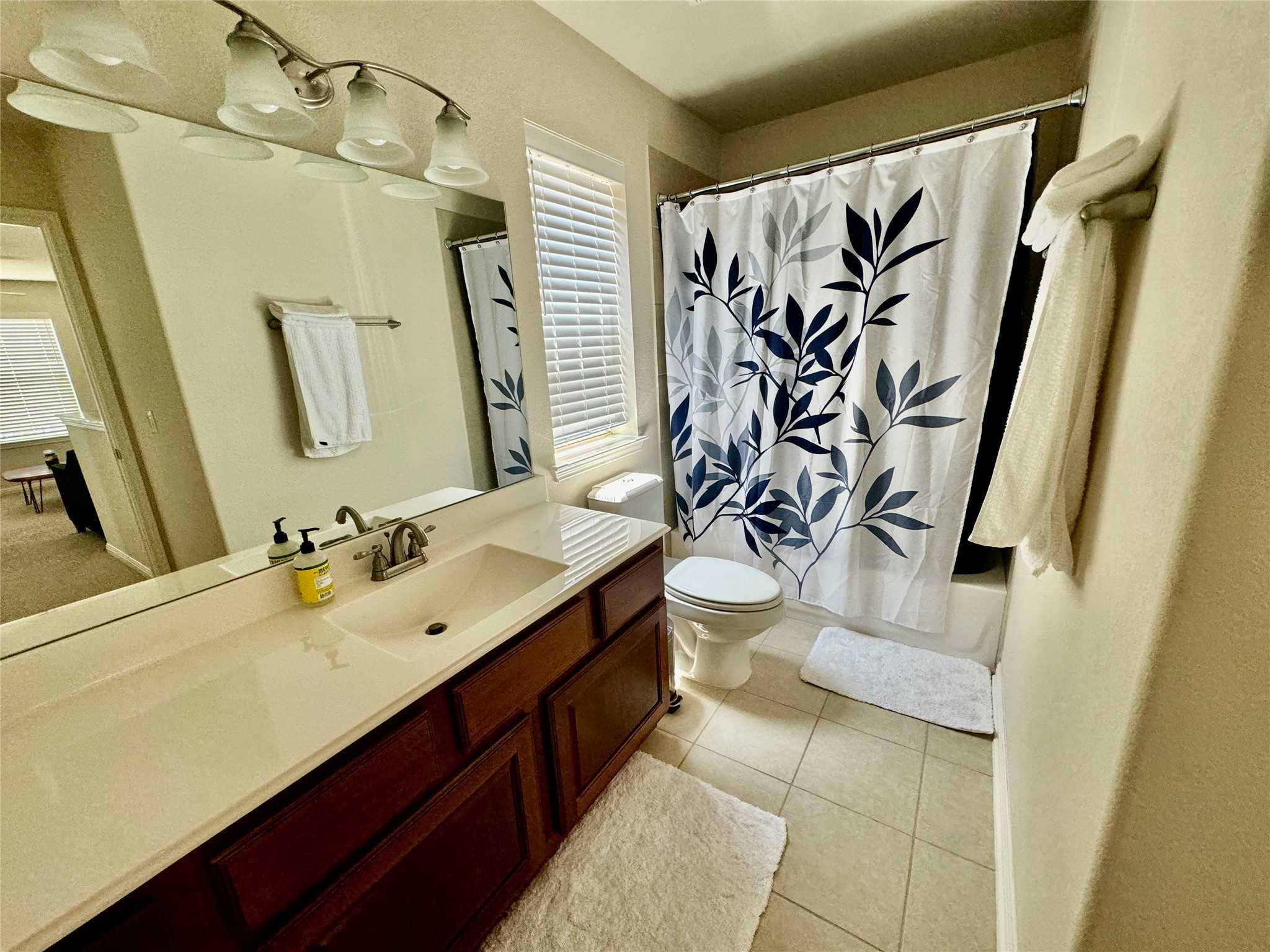 5904 Baythorne Drive Austin, TX 78747 - Photo 20 of 24 Bathroom with vanity, shower / bathtub combination with curtain, and light tile patterned floors