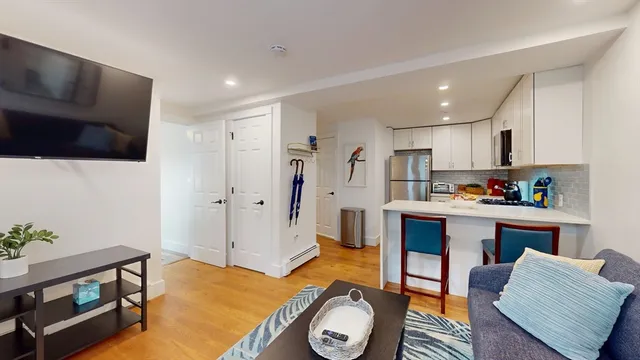 a living room with kitchen island furniture and a flat screen tv