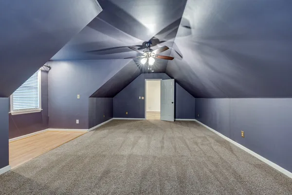 a view of an empty room and a ceiling fan