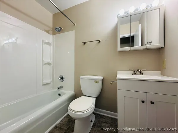 a bathroom with a toilet a sink a mirror and bathtub