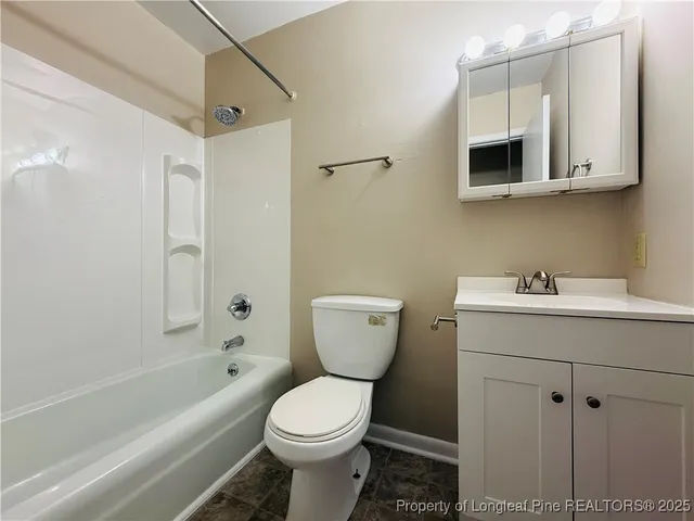 a bathroom with a toilet a sink a mirror and bathtub
